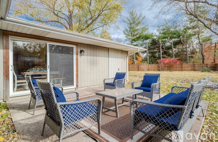 A patio with a table and chairs is set up outside a house.