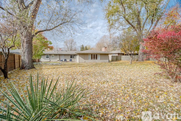 A house with a yard full of leaves in front of it.