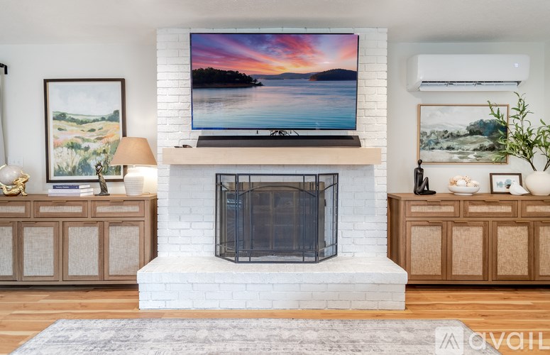 A living room with a grey sofa, a white coffee table, and a wooden floor.