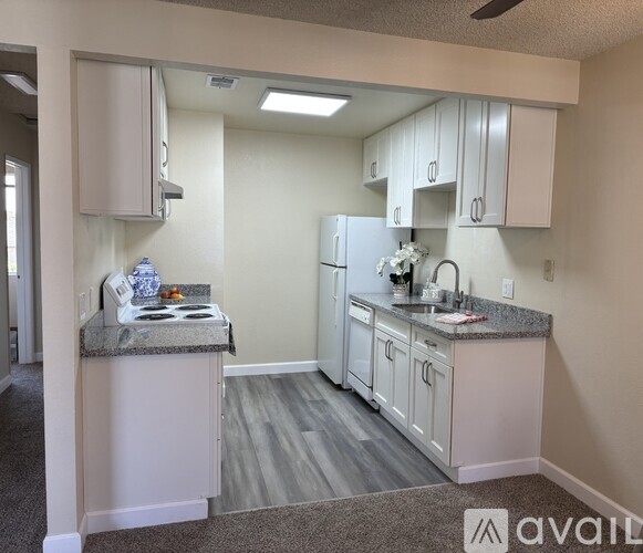 A kitchen with wooden cabinets and a white refrigerator.