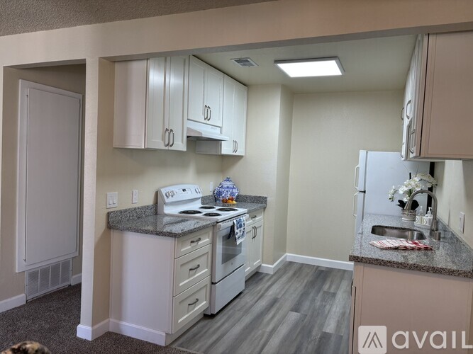 A kitchen with a stove, refrigerator, and cabinets.