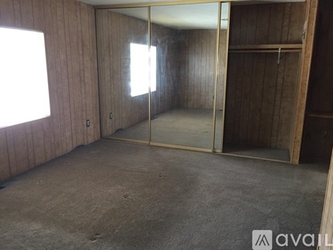 A room with a sliding glass door and wooden walls.