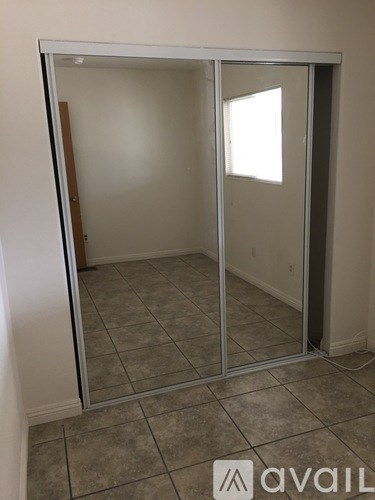 A room with a glass door and tiled floor.