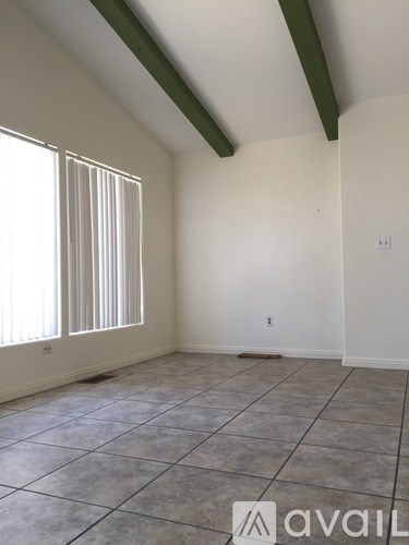 A room with a tiled floor and a window with blinds.