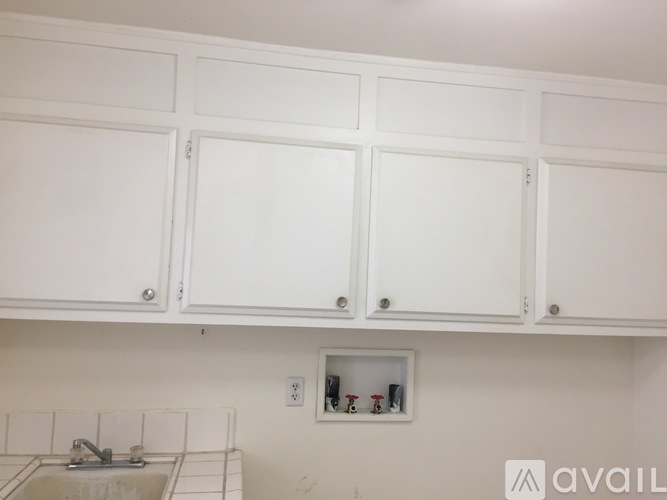 A kitchen with white cabinets and a sink.