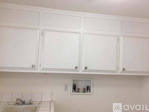 A kitchen with white cabinets and a sink.