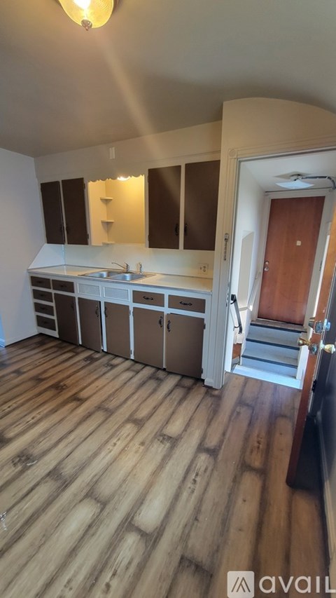 A kitchen with wooden floors and white walls.