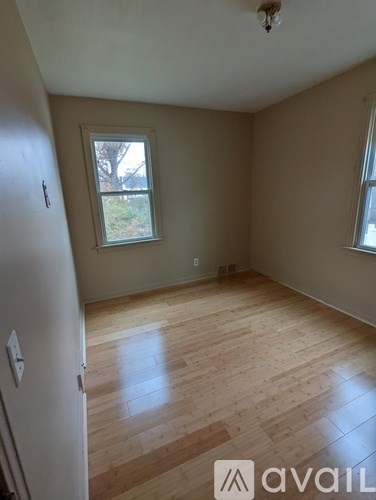 A room with wooden floors and two doors.