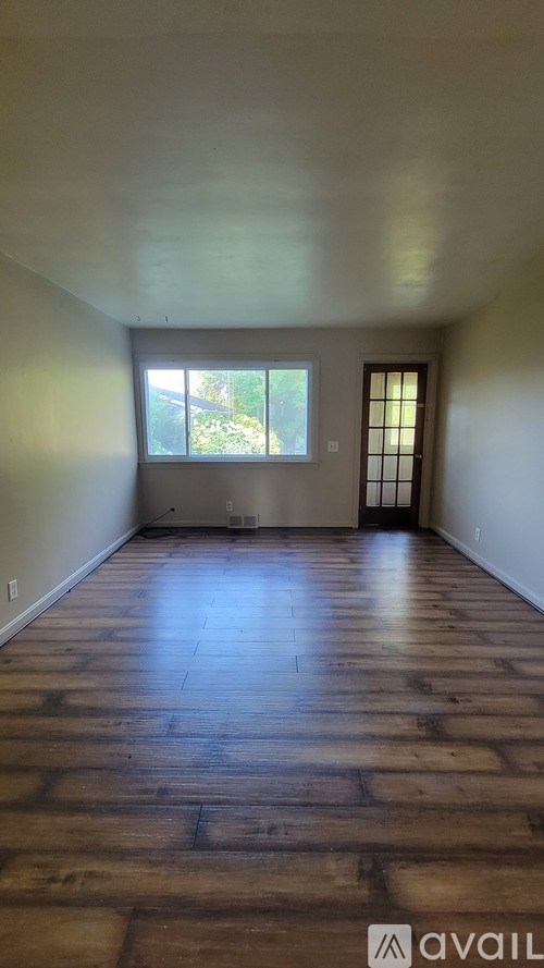 A room with wooden floors and a window.