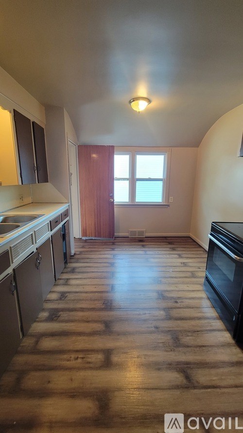 A kitchen with wooden floors and a window.