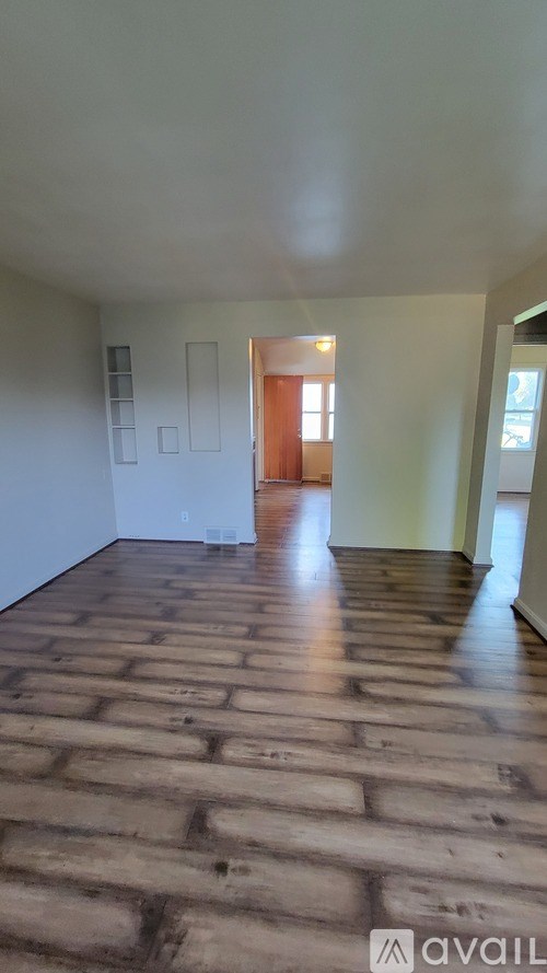 A room with wooden flooring and white walls.