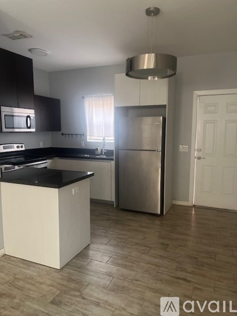A kitchen with a black countertop and a white island.