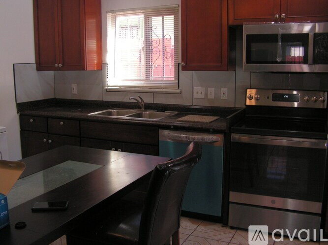 A kitchen with a black countertop and a stainless steel oven.