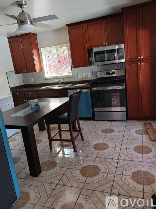 A kitchen with brown cabinets and a patterned floor.