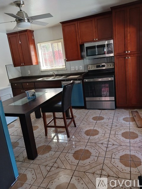 A kitchen with brown cabinets and a patterned floor.