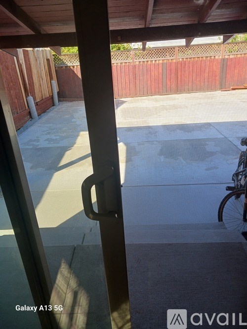 A view from inside a building looking out to a patio with a bicycle.