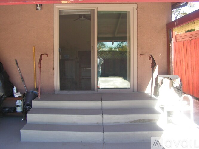 A red wall with a glass door and a set of stairs leading to it.
