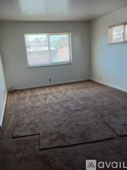 A room with a window and a carpet on the floor.