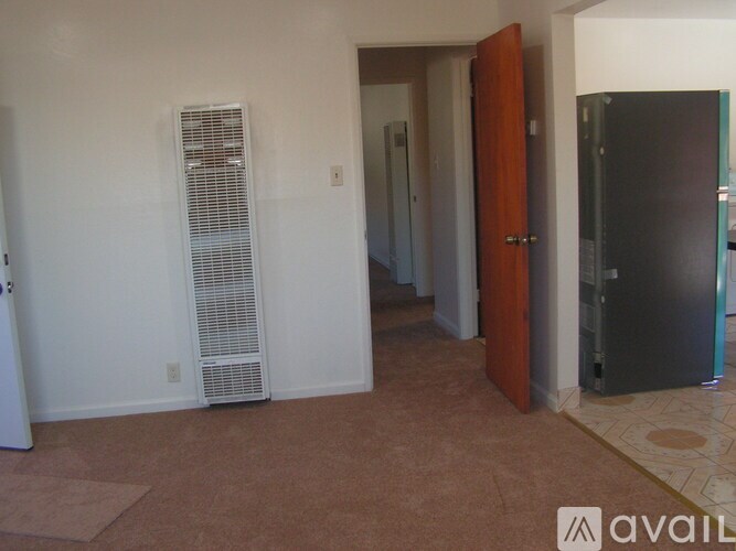 A room with a brown carpet and a brown door.