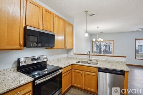 A kitchen with wooden cabinets and granite countertops.