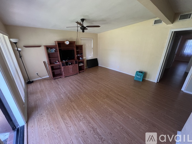 A room with wooden flooring and a ceiling fan.