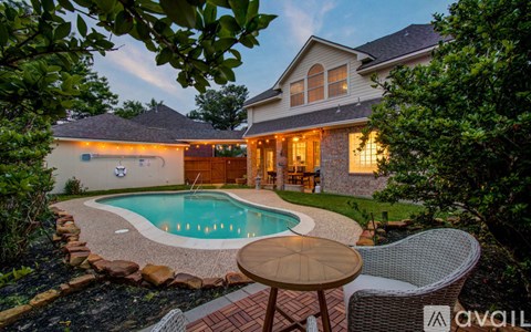 A house with a pool in front of it.