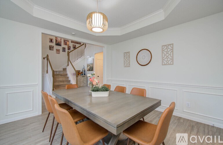 A dining room with a table and chairs.