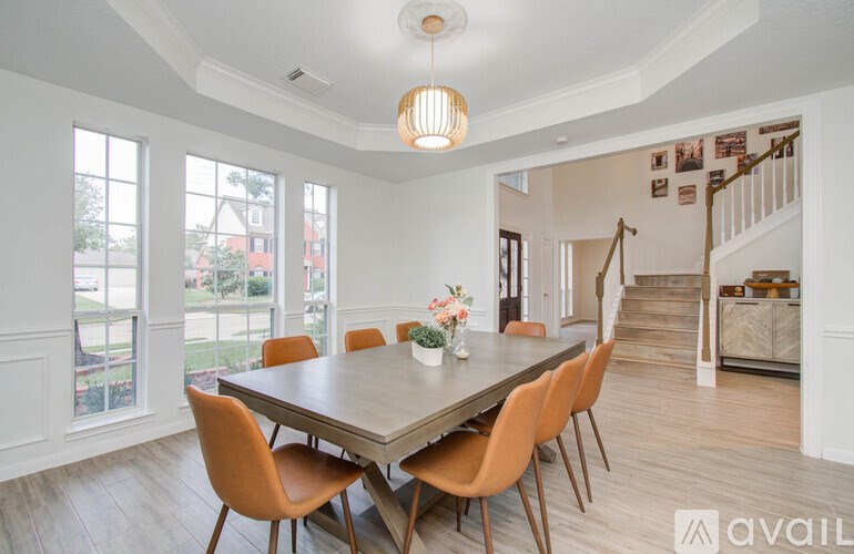A dining room with a table and chairs.