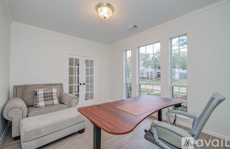A living room with a grey couch, a wooden table, and a chair.