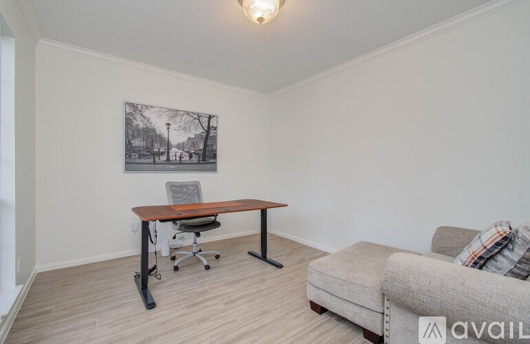 A room with a table, a couch, and a framed picture on the wall.