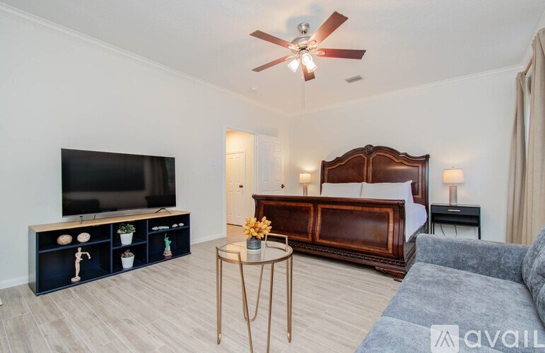 A bedroom with a bed, a television, and a coffee table.