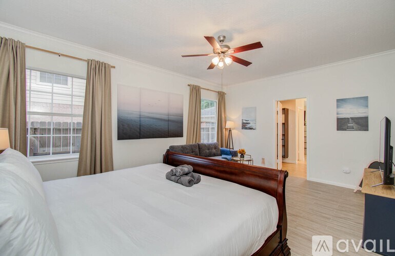 A bedroom with a large bed and a ceiling fan.