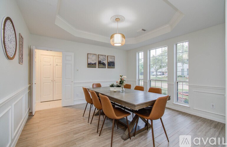 A dining room with a table and chairs.