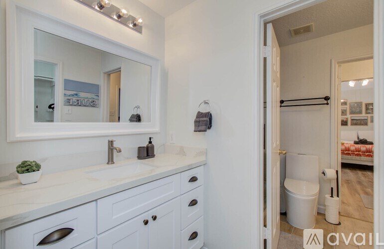 A bathroom with a white sink and a mirror above it.