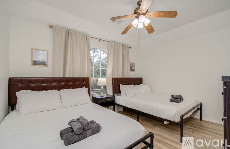 A bedroom with a large bed and a smaller bed in the corner.