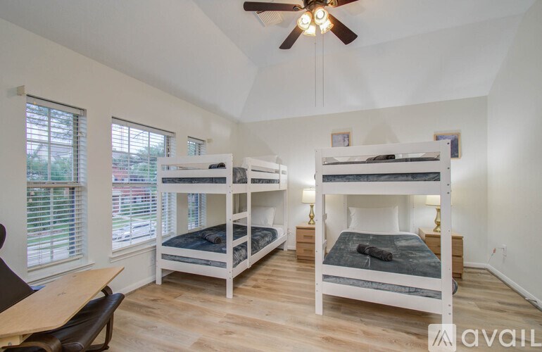 A bedroom with two bunk beds and a ceiling fan.
