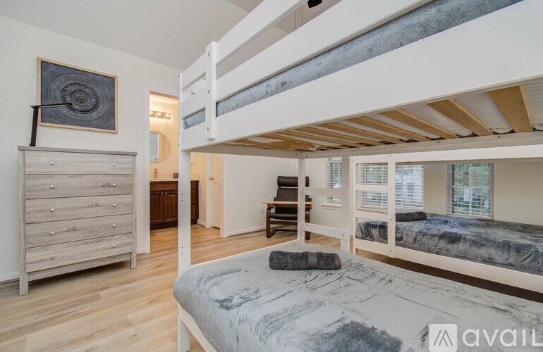A bedroom with a bunk bed and a dresser.