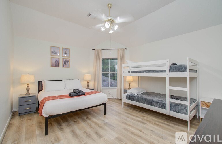 A bedroom with a white bed and a white bunk bed.