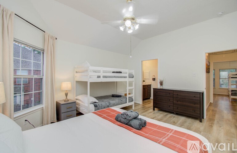 A bedroom with a bunk bed and a dresser.