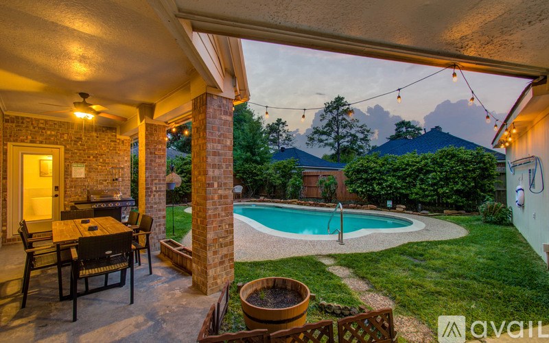 A patio with a table and chairs overlooks a pool.