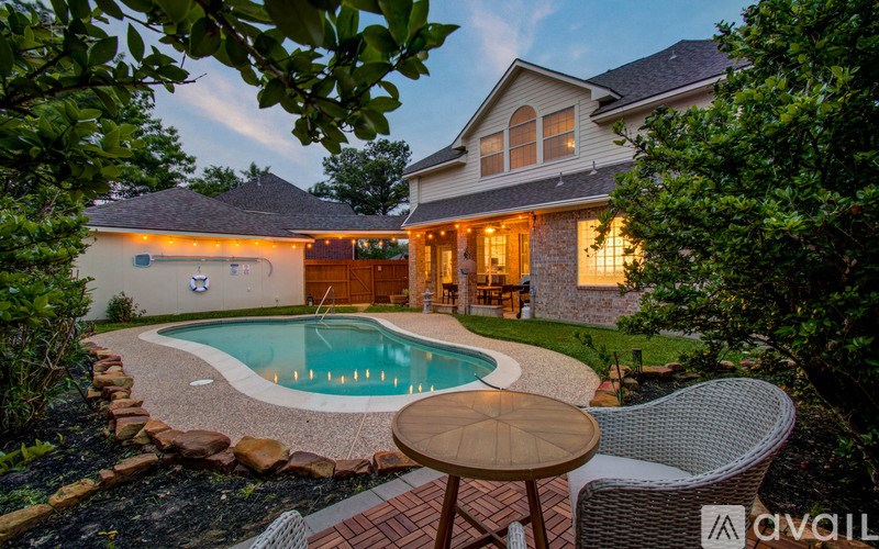 A backyard with a pool and patio furniture.