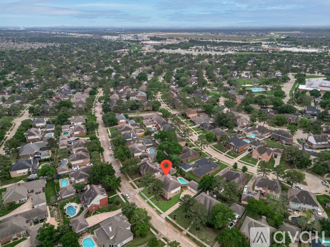 A bird's eye view of a suburban neighborhood with houses and trees.