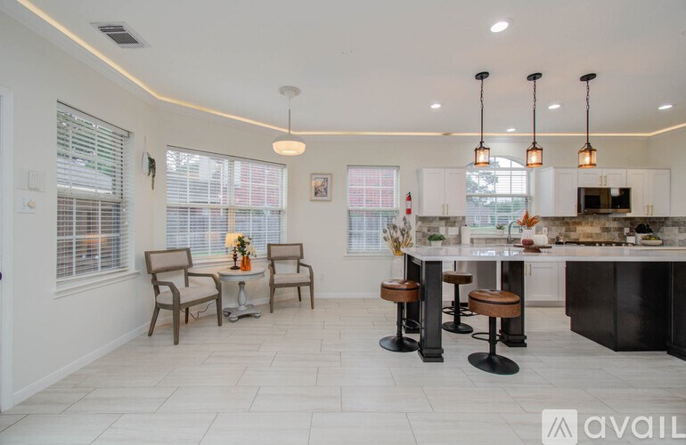 A modern kitchen with a dining area and a bar stool.