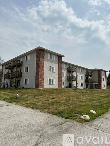 A large apartment complex with a grassy area in front.
