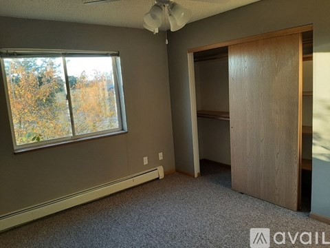 A room with a ceiling fan and a large window.