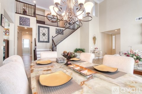 A dining room with a marble table and a chandelier.