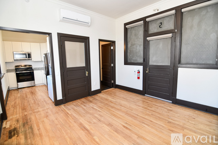 A room with wooden flooring and a brown door.