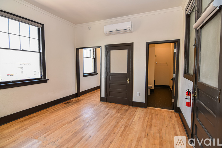 A room with wooden floors and a door on the right.