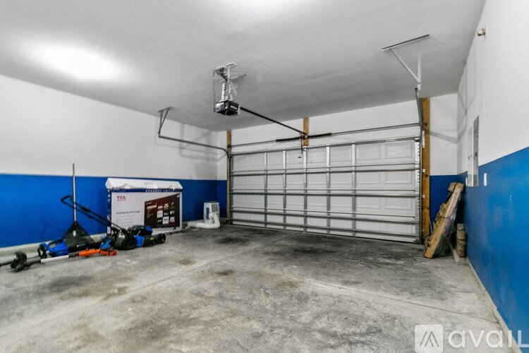 A spacious garage with a white ceiling and a closed white garage door.