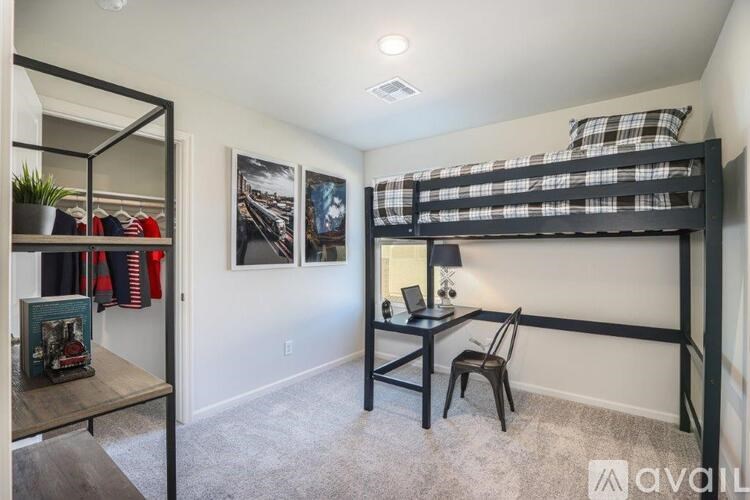 A room with a bunk bed and a desk with a chair.